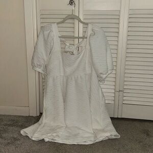 White fluffy dress, flowy skirt, puffy sleeves, two strands in back to tie